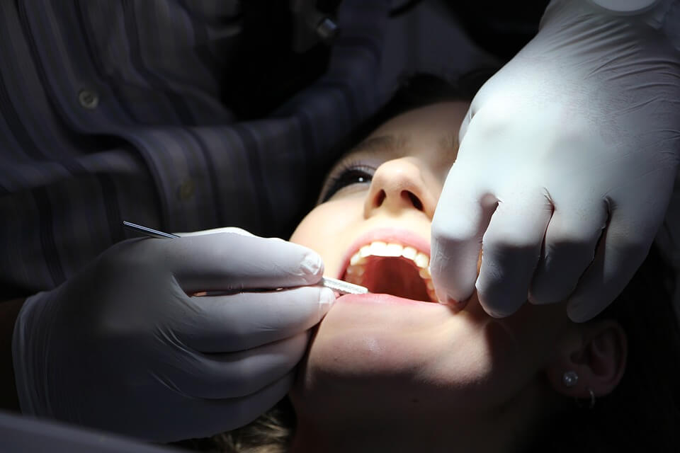 A dentist checks the teeth of a patient.